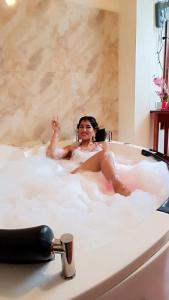 une femme est assise dans une baignoire dans l'établissement HOTEL WISMONT, à La Merced