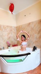 une femme dans une baignoire avec un ballon rouge dans l'établissement HOTEL WISMONT, à La Merced