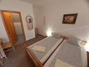 um pequeno quarto com 2 camas e um espelho em Pivní lednice em Lhota pod Libčany