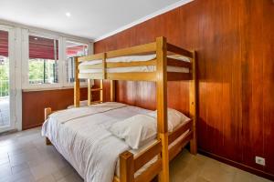 コスタ・ダ・カパリカにあるCaparica Beach Charmingの二段ベッドが備わる木製の壁の客室です。