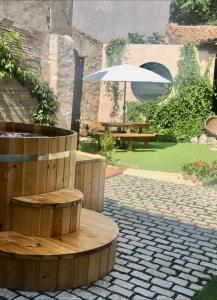 a wooden bench with an umbrella in a garden at La Casona del Tío Pedro in Cadalso de los Vidrios