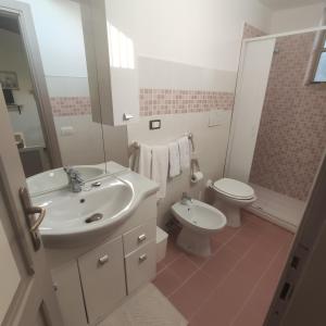 ein weißes Bad mit einem Waschbecken und einem WC in der Unterkunft Regina sul Mare in Terracina