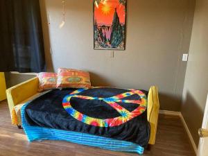 Una cama con una manta de colores en una habitación en Hippie Haus next to iconic BBQ restaurant, en Lakehills
