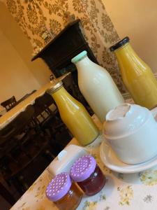 Nettleton Country House في Nettleton: مجموعة من ثلاث زجاجات من الحليب على طاولة