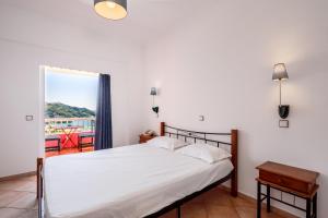 a bedroom with a bed and a window with a view at Pink Palace Beach Resort in Agios Gordios