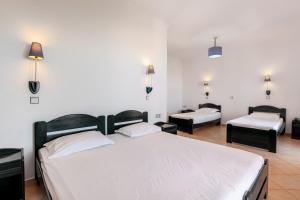 a bedroom with a large bed and two beds at Pink Palace Beach Resort in Agios Gordios