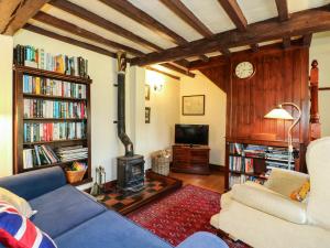 a living room with a couch and a fire place at Granary Cottage in Oasby