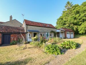 an old house with a garden in the yard at Granary Cottage in Oasby