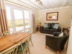 a living room with a table and a couch at Oak Cottage in Caernarfon