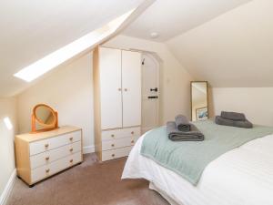 a bedroom with a bed and a dresser and a mirror at Oak Cottage in Caernarfon