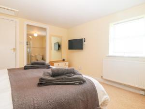 a bedroom with two beds with towels on them at Oak Cottage in Caernarfon