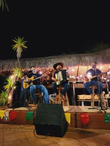 um grupo de pessoas tocando música em um palco em Hotel Fazenda Cachoeiras Serra da Bodoquena em Bodoquena