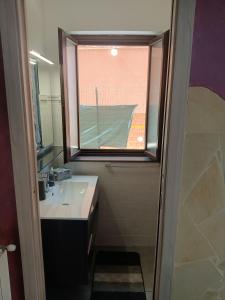een badkamer met een wastafel en een raam bij Delilah's house in Catania