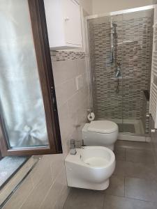 een badkamer met een toilet, een wastafel en een douche bij Delilah's house in Catania