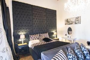 La Corte Della Regina في كاتانيا: غرفة نوم مع اللوح الأمامي الأسود الكبير وسرير
