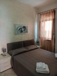 een slaapkamer met een bed met twee handdoeken erop bij Delilah's house in Catania