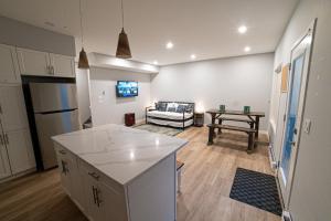 een keuken en een woonkamer met een bank en een tafel bij Kid & Pet Friendly Walkout BSMT 90 mins to Banff and 30 mins to Downtown Calgary in Calgary