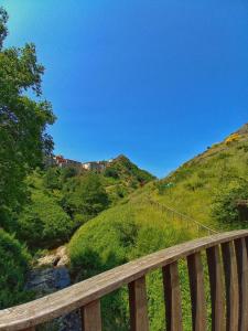 a wooden bridge over a river on a hill at La torre della manca suite in Sasso di Castalda