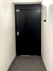 サン・テティエンヌにあるHôtel QUAI33の黒いドア付きの廊下