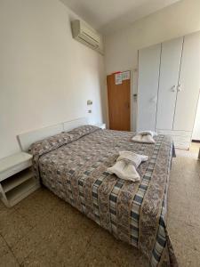 1 dormitorio con 1 cama con 2 toallas en Mehari Hotel Rimini en Rímini