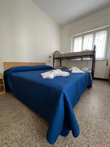 Un dormitorio con una cama azul con toallas. en Mehari Hotel Rimini en Rímini