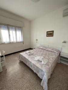 sypialnia z łóżkiem z dwoma ręcznikami w obiekcie Mehari Hotel Rimini w Rimini