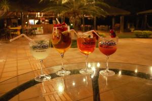 four wine glasses sitting on top of a table at Hotel Fazenda Cachoeiras Serra da Bodoquena in Bodoquena