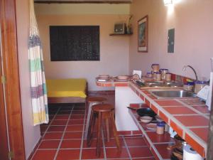 cocina con encimera, fregadero y sofá en El Yaque Ranch en El Yaque