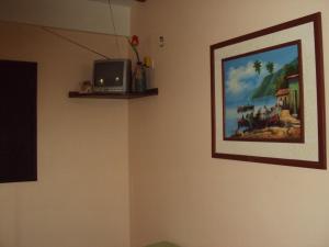 a room with a picture and a tv on a wall at El Yaque Ranch in El Yaque