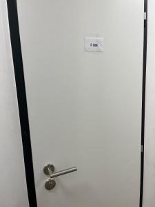 een witte deur met een bord erop bij Apartmán Pod svahem in Loučná pod Klínovcem