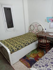 a bedroom with a bed and a desk and a table at سوهاج الجديدة 