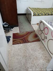 twee bedden in een kamer met matten op de vloer bij سوهاج الجديدة 