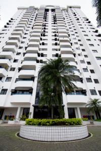 un gran edificio blanco con una palmera delante en Aconchegante e Completo Apartamento de 2 Quartos - próximo ao Parque Olímpico, Rio Centro, Jeunesse Arena, en Río de Janeiro