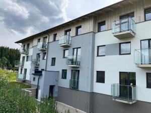 ein Apartmenthaus mit Balkon an der Seite in der Unterkunft Apartmán Pod svahem in Loučná pod Klínovcem