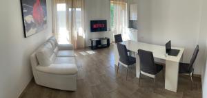 ein Wohnzimmer mit einem Sofa und einem Tisch mit einem Laptop in der Unterkunft Lux Kuoni Grace - Appartamento a due passi dal porto in Civitavecchia
