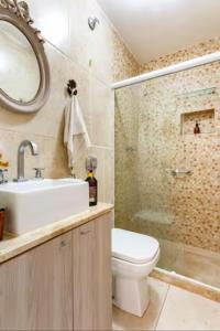 a bathroom with a toilet and a sink and a shower at Quarto em casa de vila em Botafogo, Rio de Janeiro in Rio de Janeiro