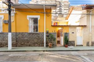 une maison avec un mur jaune dans l'établissement Quarto em casa de vila em Botafogo, Rio de Janeiro, à Rio de Janeiro