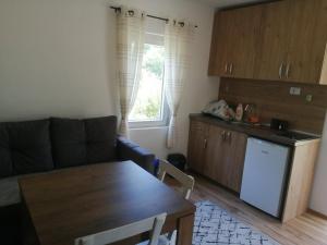 ein Wohnzimmer mit einem Sofa und einem Tisch sowie eine Küche in der Unterkunft Zelena livada (Green Meadow) in Bijelo Polje