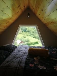 ein Fenster in einem Zimmer mit einem Bett und Aussicht in der Unterkunft Zelena livada (Green Meadow) in Bijelo Polje