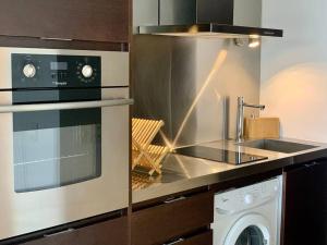 La cocina está equipada con fogones, horno y lavavajillas. en Divino apartamento en edificio de lujo en Punta del este en Punta del Este
