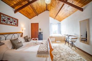 a bedroom with a bed and a living room with a table at Pousada Nascer da Lua in Monte Verde