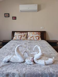 two swans made out of towels on a bed at Pavlonya Bungalows in Mugla