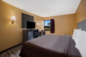 a hotel room with a bed and a flat screen tv at Econo Lodge in Allentown