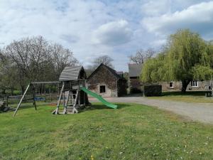 a playground with a slide and a swing at Les Petites rives de la Motte in Pleugueneuc