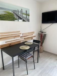 a black table and chairs in a room with a painting at Appartement le Jules VERNE in Le Crotoy