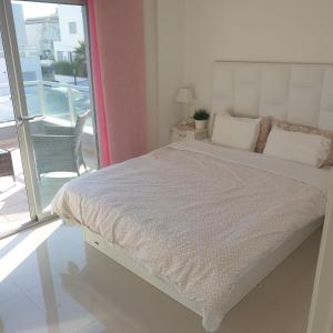 uma cama branca num quarto com uma janela em Marinamed Residential Villa Sea View em Orihuela Costa