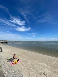 a couple of people laying on the beach at Appartement le Jules VERNE in Le Crotoy