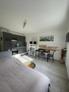 a bedroom with a bed and a table and a kitchen at Appartement le Jules VERNE in Le Crotoy