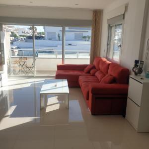 uma sala de estar com um sofá vermelho e uma mesa em Marinamed Residential Villa Sea View em Orihuela Costa