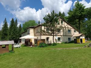 a large house with a large yard in front of it at Leśny Domek in Bystrzyca Kłodzka